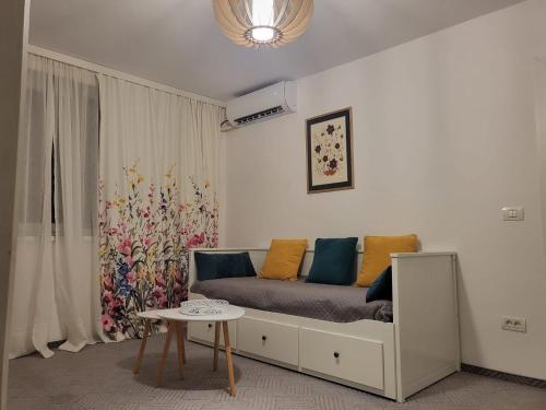 a living room with a bed and a table at Concordia - apartament lângã Cazino in Băile Herculane