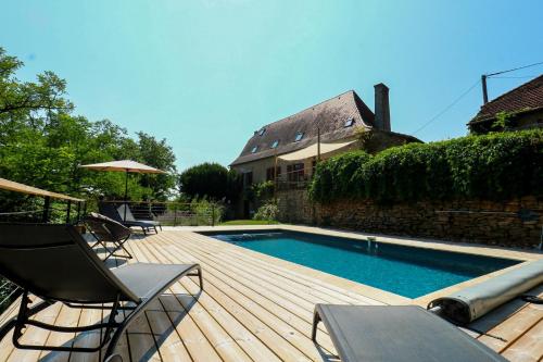 une terrasse avec une piscine, des chaises et une maison dans l'établissement La Maison de Pierrot, à Rignac