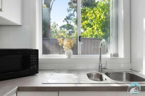 a kitchen counter with a sink and a window at Aircabin - Colyton - Modern - 2-Bed Granny Flat in Colyton