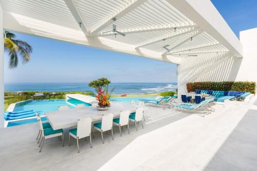 an outdoor patio with a table and chairs and a swimming pool at Casa Brisa Luxury on The Beach in Punta Mita