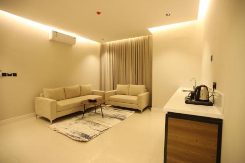 a living room with two chairs and a table at افال للشقق المخدومة-اليرموك in Riyadh