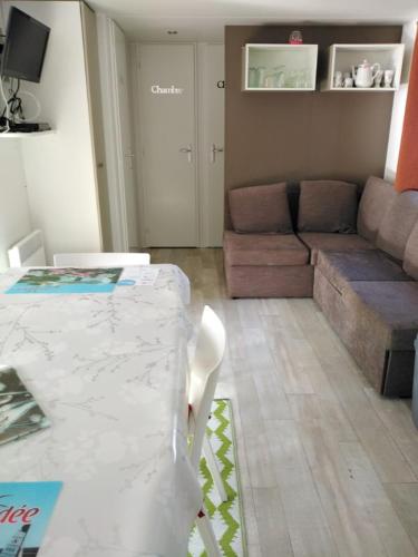 un salon avec une table et un canapé dans l'établissement Mobil home 6 à 8pers, à Saint-Jean-de-Monts