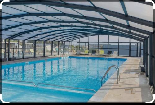 une grande piscine avec un toit en métal dans l'établissement cottage Landes entre terre et ocean, à Saubrigues