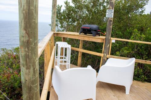 a deck with two chairs and a grill at The Hive - Cloud at Misty Mountain Reserve in Stormsrivier