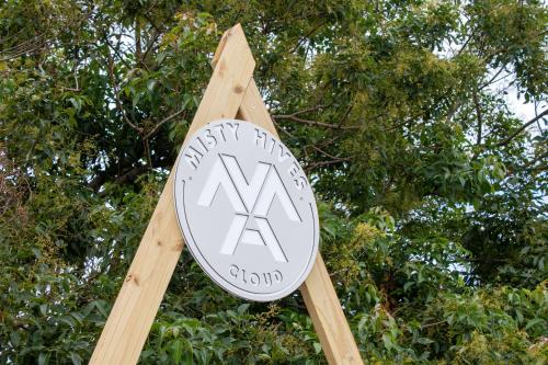 a clock on a wooden pole with trees in the background at The Hive - Cloud at Misty Mountain Reserve in Stormsrivier