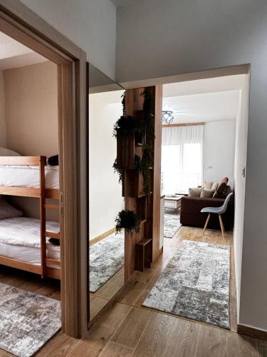 a living room with a mirror and a bedroom at Crown Apartmani Vlašić in Vlasic