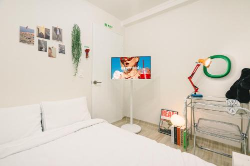 a white bedroom with a bed and a mirror at Cozy Gangnam Jamsil KSPO DOM in Seoul
