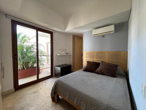 a bedroom with a bed and a large window at Edificio Casa de Río in Santa Marta