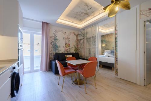 un soggiorno con tavolo, sedie e un letto di GRAN VIA capitals by MONARO***** a Madrid