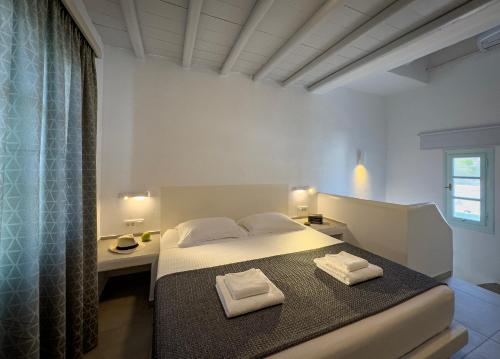 a bedroom with a bed with two towels on it at ANETON Residences in Karavostasi