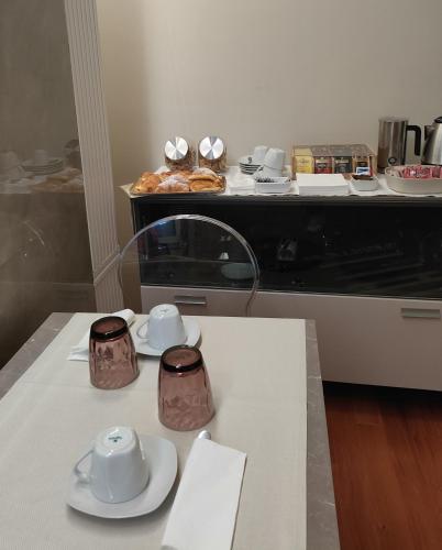 a kitchen with a table with cups and plates on it at Malva B&B in Reggio Calabria