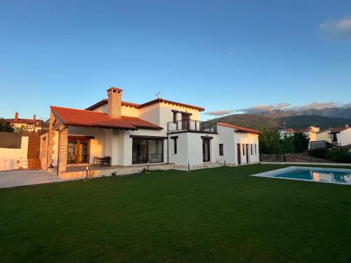 a house with a large yard and a swimming pool at El Legado de Gredos in Candeleda