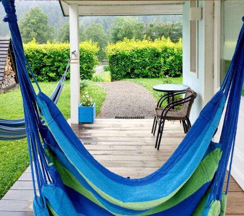 a hammock on the porch of a house at Osada Leonówka Bieszczady in Cisna