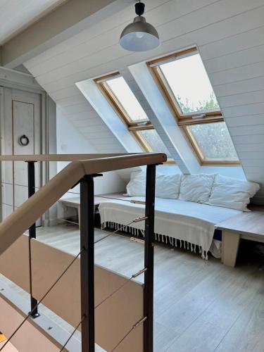 Cette chambre mansardée comprend 2 lits et 2 fenêtres. dans l'établissement 1h10 de Paris, maison de campagne avec piscine chauffée, à Mainneville