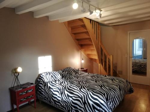 a zebra print bed in a room with a staircase at 8 seater house near Chinon in Beaumont-en-Véron