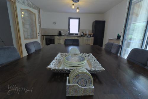a dining room table with a bowl and plates on it at Villa Emma in Zovik