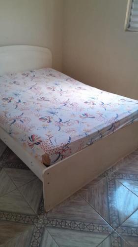 a bed in a room with a floral bedsheet at Recanto Azedo e Azedinhas Itu Mairinque in Itu