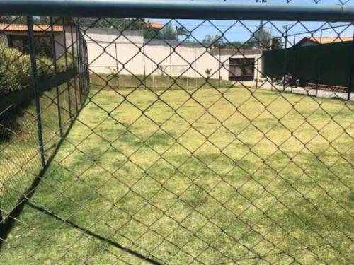 a chain link fence with a field of grass at Recanto Azedo e Azedinhas Itu Mairinque in Itu