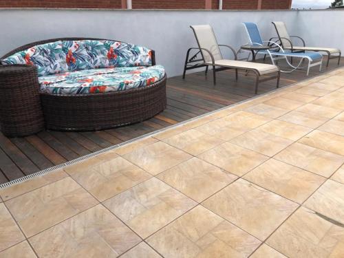a patio with a couch and chairs and a table at Recanto Azedo e Azedinhas Itu Mairinque in Itu