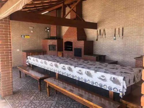 a large bed in a brick room with benches at Recanto Azedo e Azedinhas Itu Mairinque in Itu
