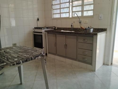 een keuken met een aanrecht, een wastafel en een fornuis bij Casa azul da Serra in São Pedro