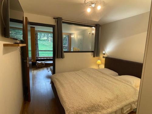 une chambre avec un lit et un grand miroir dans l'établissement Arc 1800 - Les Lauzières Sud - Bel appartement double 6-8 personnes, à Arc 1800