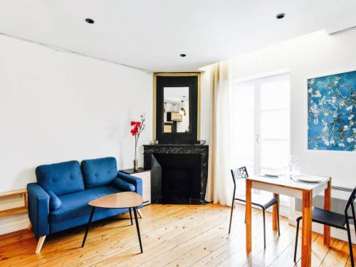 un salon avec un canapé bleu et une table dans l'établissement Superbe appartement d'architecte place du Capitole, à Toulouse