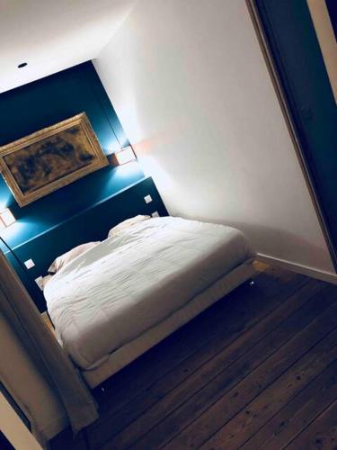 - un petit lit dans une chambre dotée d'un mur bleu dans l'établissement Superbe appartement d'architecte place du Capitole, à Toulouse