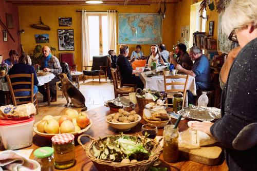 a group of people sitting at tables in a restaurant at Gîte La Grange Du Haut in Saint-Antoine