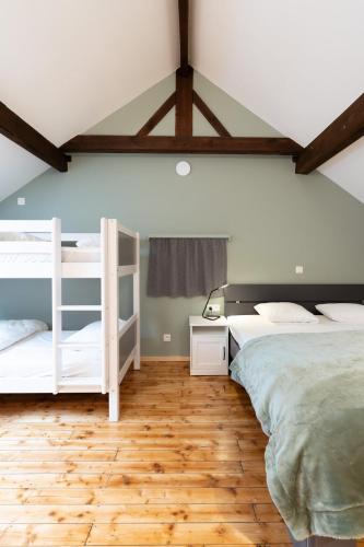 a bedroom with two bunk beds and a wooden floor at Charmette, cozy home for 9p in La-Roche-en-Ardenne