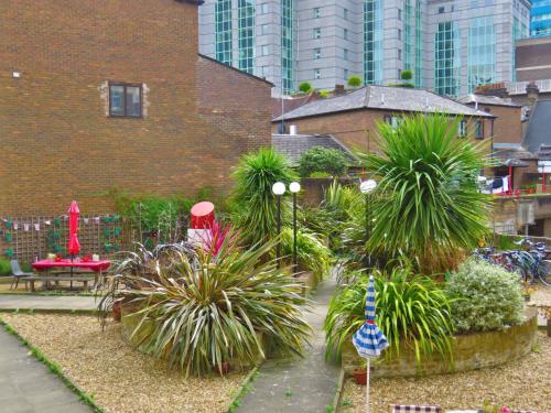 a garden with plants in front of a building at Central London Spitalfields Apartment in London