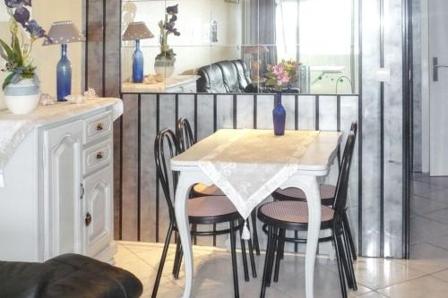 une salle à manger avec une table et des chaises blanches dans l'établissement Appartement confortable au Cap d'Agde 55 m² avec vue mer, au Cap d'Agde