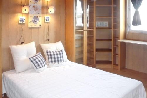 une chambre avec un lit avec des draps blancs et des oreillers dans l'établissement Appartement confortable au Cap d'Agde 55 m² avec vue mer, au Cap d'Agde