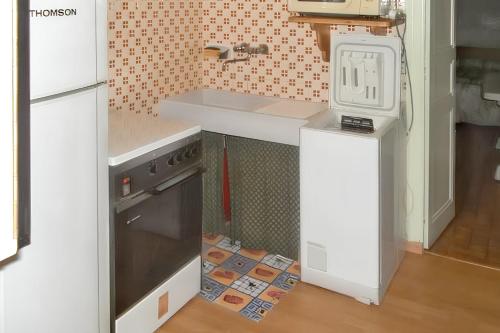 une cuisine avec un évier et une cuisinière dans l'établissement Appartement charmant à Rouffilhac avec vue sur jardin, à Rouffilhac