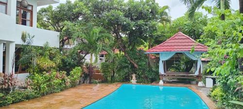 a villa with a swimming pool and a gazebo at Mimpi Bungalow 3A in Kubutambahan