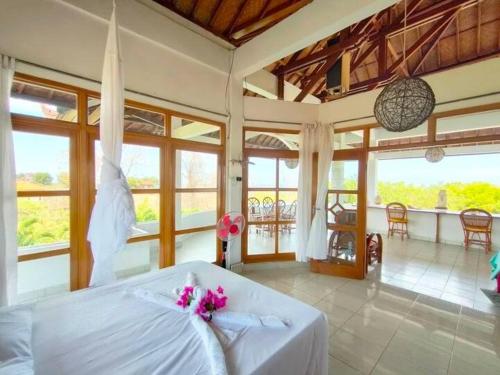 a bedroom with a white bed with pink flowers on it at Mimpi Bungalow 3A in Kubutambahan