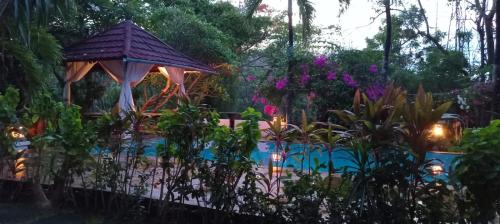 a garden with a gazebo and a swimming pool at Mimpi Bungalow 3A in Kubutambahan