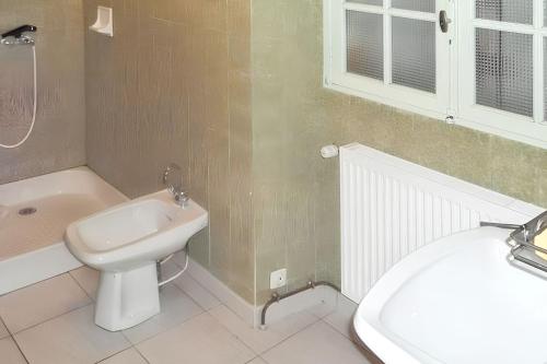 RouffilhacにあるAppartement charmant à Rouffilhac avec vue sur jardinの洗面台、トイレ、浴槽を備えたバスルーム
