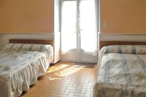 RouffilhacにあるAppartement charmant à Rouffilhac avec vue sur jardinの窓付きの客室で、ベッド2台が備わります。