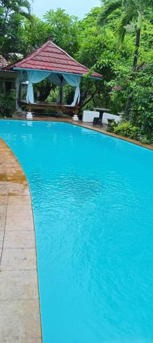 a large blue swimming pool with a gazebo at Mimpi Bungalow 3A in Kubutambahan