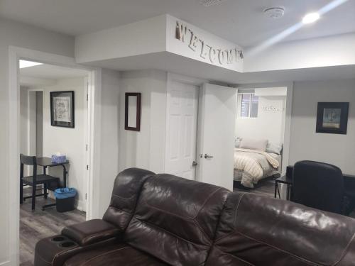 a living room with a leather couch and a bed at Velohome - 3-Bed, 2-Bath Home in Milton