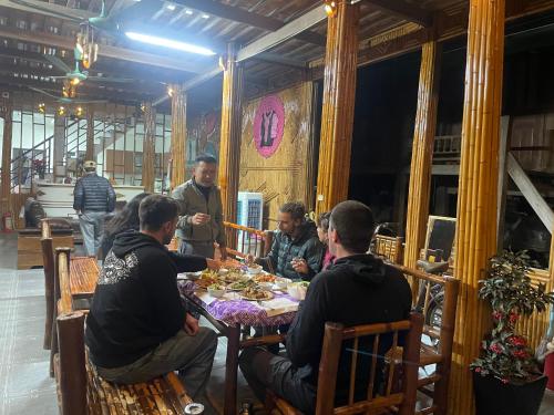a group of people sitting around a table in a restaurant at Mai chau Horizon Homestay in Mai Chau