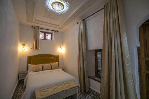 a small bedroom with a bed and a window at Dar Mima in Fès