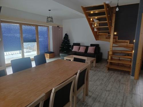 a living room with a wooden table and a staircase at Bajka w Gliczarowie in Bukowina Tatrzańska