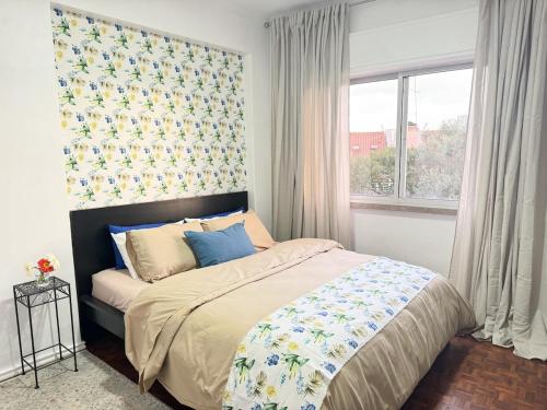 a bedroom with a large bed and a window at Cozy apartment in Paço de Arcos