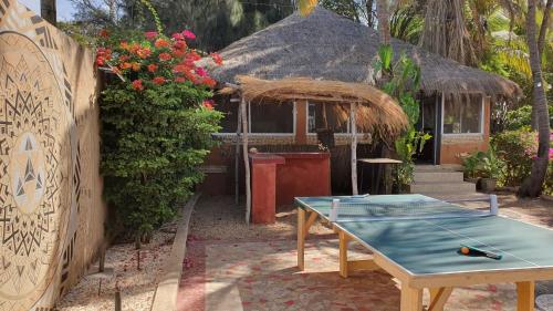 a ping pong table in front of a house at LE BENTENIER Home Détente in Nianing