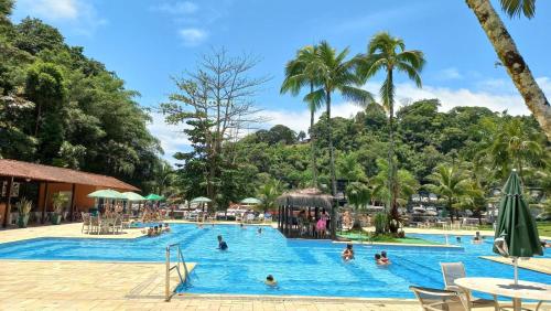 una piscina in un resort con persone di Casa inteira na PRAIA & SERRA Melhor Resort Angra a Conquista