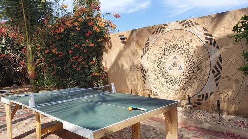 a ping pong table in front of a wall at LE BENTENIER Home Détente in Nianing