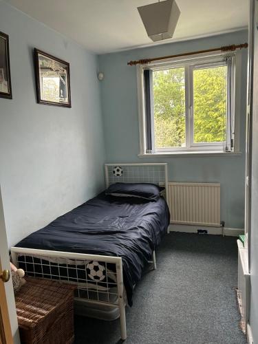 a bedroom with a bed and a window at Cosy 3 bedroom house to rent in Manchester