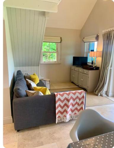 a living room with a couch and a television at The Little House in Ballynacarrow